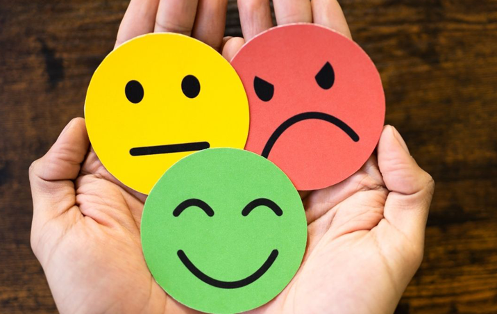 hand holding faces with expressions